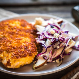 Paniertes Schnitzel mit Zwiebeln und Reis nach griechischer Art